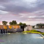Custom community entrance with metal scupper water feature, real grass and natural stone accents.