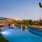 Custom backyard design with uplighting, multiple seating areas and artificial turf.