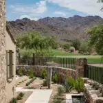 Custom backyard design with organized planting, natural stone accents and metal scupper water feature.