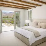 Custom indoor/outdoor fusion with natural stone accents, blue pool and organized planting.