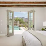 Custom indoor/outdoor fusion with natural stone accents, pool and organized planting.