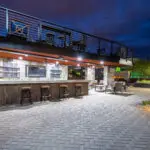 Custom patio design with two-story shade structure, uplighting and fireplace.