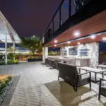 Custom patio design with metal fencing, multiple seating areas and patterned paver decking.