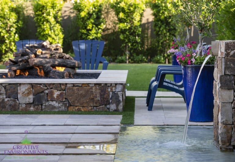 Custom backyard design with natural stone columns, Jesus steps and large, square fire pit.
