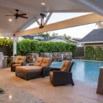 Custom farmhouse shade structure with outdoor fan, multiple seating areas and beer tap.