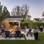 Custom backyard design with large, natural stone steps, farmhouse shade structure and large planters.