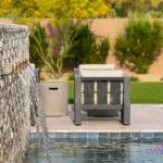 Custom backyard design with metal scupper water feature into pool, real grass and outdoor seating area.