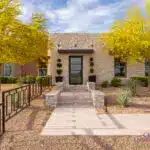 Custom front yard design with metal gence, topiaries and desert landscape design.