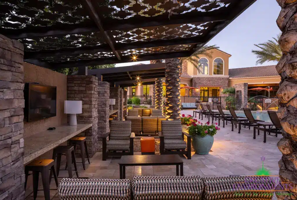 Custom community amenities with patterned metal shade structure, multiple seating areas and outdoor TVs.