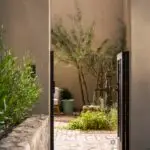 Custom side metal door with faucet water feature and pavers.