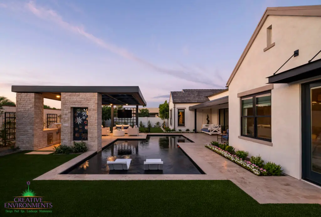 Custom backyard design with unique shaped pool, floral metal cutouts and natural stone decking.