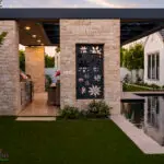Custom backyard design with floral metal cutouts, black pool and artificial turf.