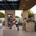 Custom metal shade structure with recessed lighting, floral metal cutouts and multiple seating areas.