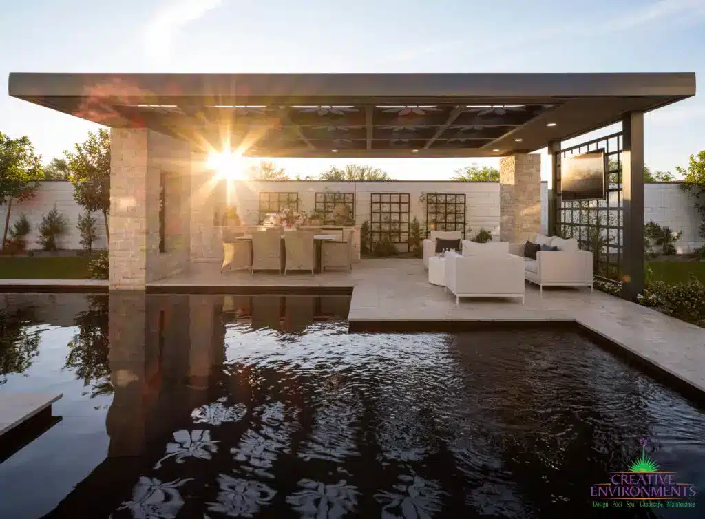 Custom backyard design with custom metal shade structure, metal trellis and black pool.