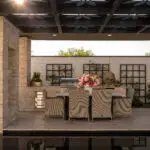 Custom metal shade structure with floral cutouts and natural stone columns.