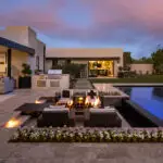 Custom backyard design with flowers, sunken fire pit and multiple seating areas.