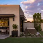 Custom backyard design with organized planting, large metal planters and artificial turf.