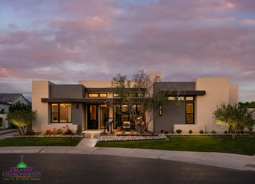 Custom front yard design with real grass, organized planting and up lighting.