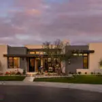 Custom front yard design with real grass, organized planting and up lighting.