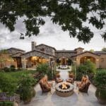Aerial view of custom backyard design with fire pit, water feature and real grass.