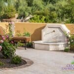 Backyard design with water feature and multiple plants.