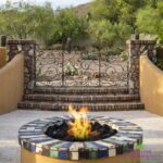 Backyard design with brick steps, fire pit and metal gate.