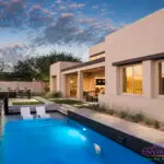Custom backyard design with blue pool with baja step and black water wall.