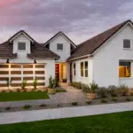 Custom front yard design with organized planting, brick paver walkway and large planters.