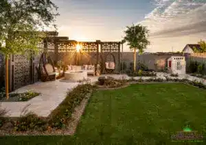 Custom backyard design with real grass, cantilevered shade structure with hanging swings and up lighting.
