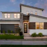 Custom front yard design with organized planting, artificial turf and up lighting.