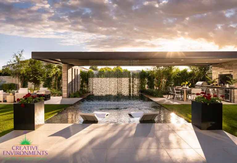 Custom backyard design with rain curtain water feature, baja step and zero-edge pool.