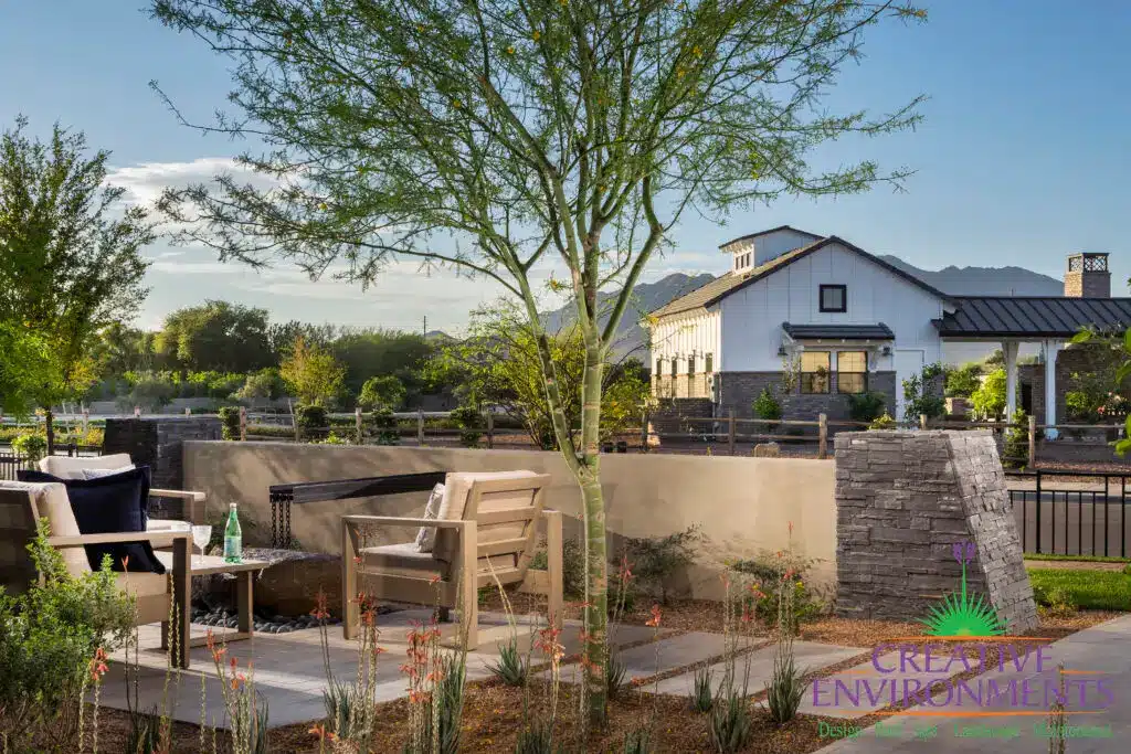 Custom community entrance with metal scupper water feature, multiple seating areas and metal fencing.