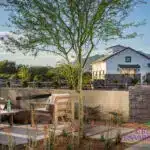 Custom community entrance with metal scupper water feature, multiple seating areas and metal fencing.