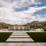 Custom backyard design with natural stone steps, unique shaped pool and multiple seating areas.