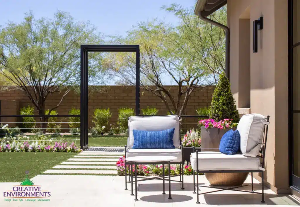 Custom backyard design with metal archway, outdoor seating area and planters.
