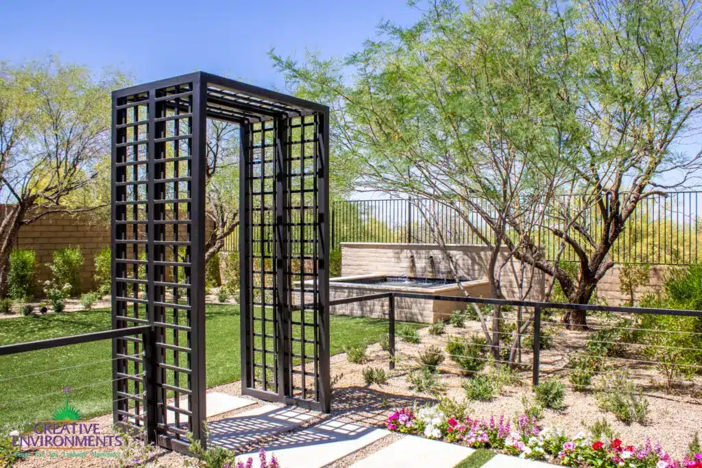 Custom metal archway, metal fencing and water feature in zen garden.