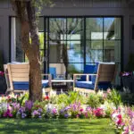 Custom backyard design with outdoor entertainment area, large planters and annuals.