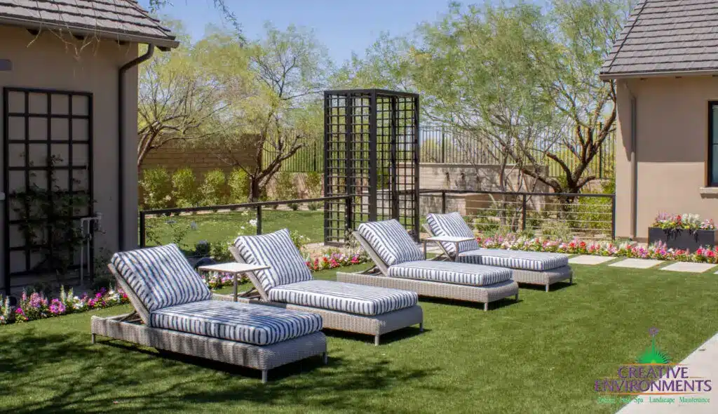 Custom backyard design with metal archway, water feature and lounge area.