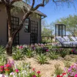 Custom backyard design with metal trellis, organized planting and artificial turf.