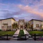 Custom front yard design with stone pillars, artificial turf and natural stone paver walkways.