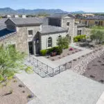 Custom front yard design with metal fencing, paver driveway and organized planting.