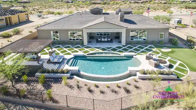Custom backyard design with artificial turf pattern, unique shaped pool and slatted shade structure.