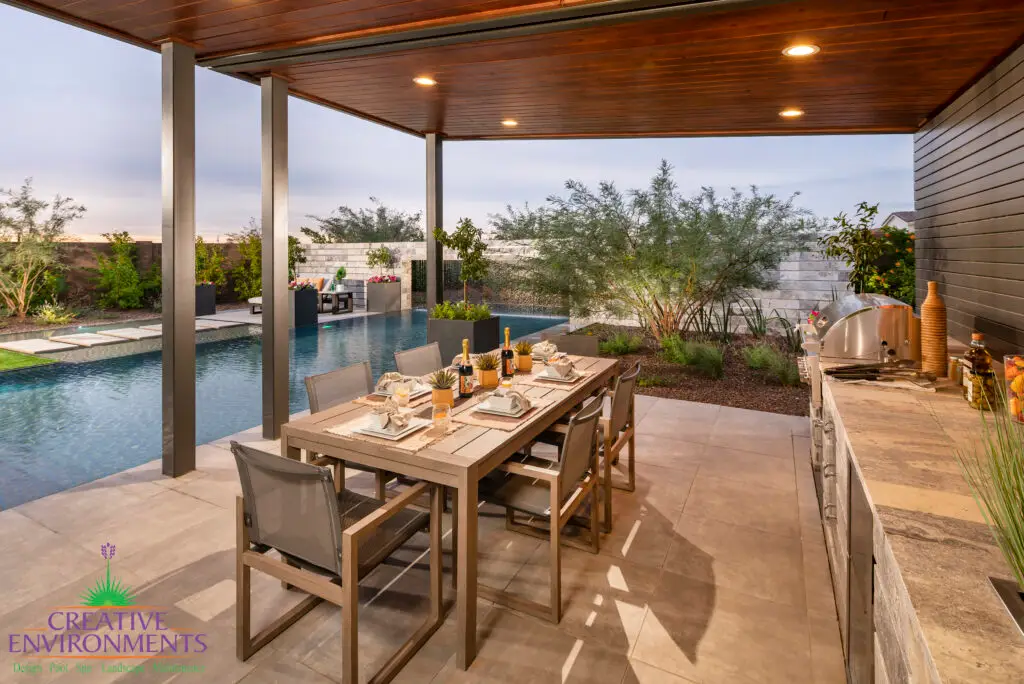 Backyard design with outdoor shade structure with recessed lighting and outdoor dining area.
