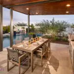 Backyard design with outdoor shade structure with recessed lighting and outdoor dining area.