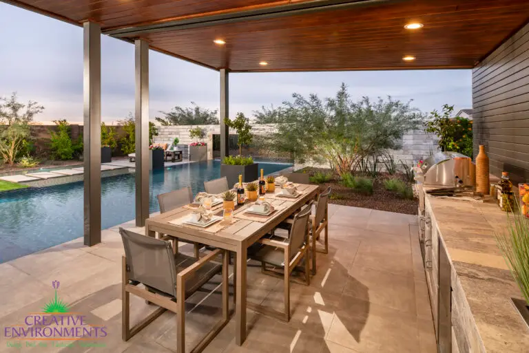 Backyard design with outdoor shade structure with recessed lighting and outdoor dining area.