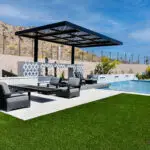 Custom backyard design with cantilevered shade structure, multiple seating areas and blue pool.