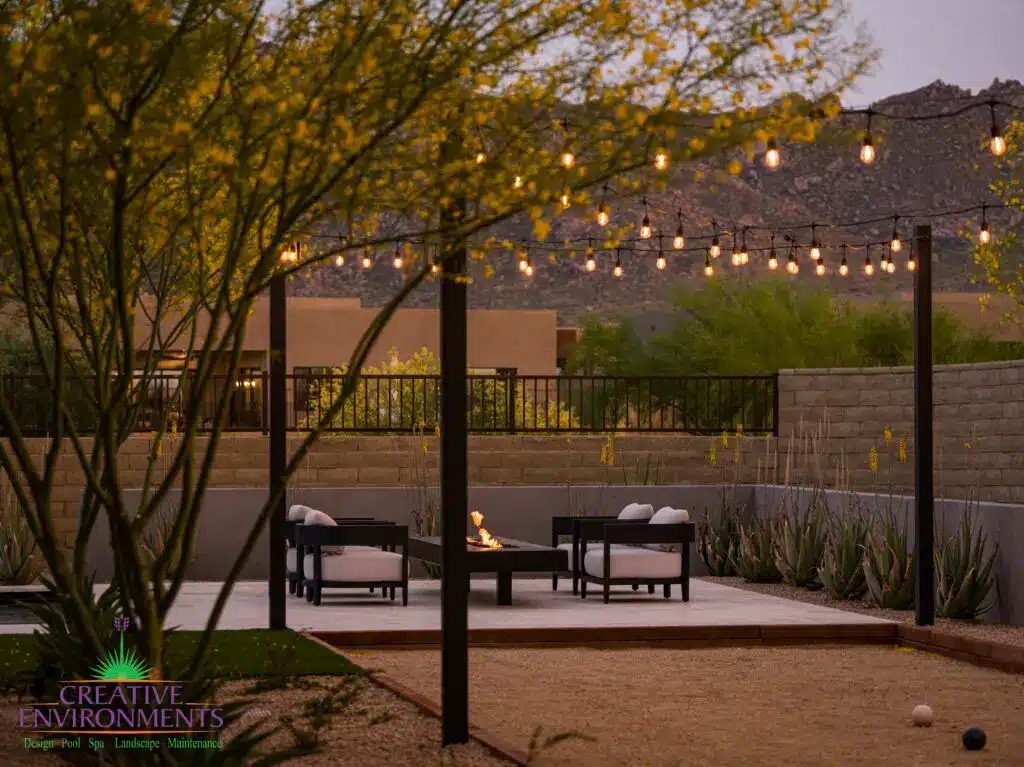 Custom backyard design with string lights, cantilevered fire table and bocce ball court.