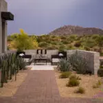 Custom front yard design with privacy wall, metal scupper water feature and outdoor seating area.