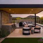 Custom backyard design with metal shade structure, outdoor entertainment area and artificial turf.