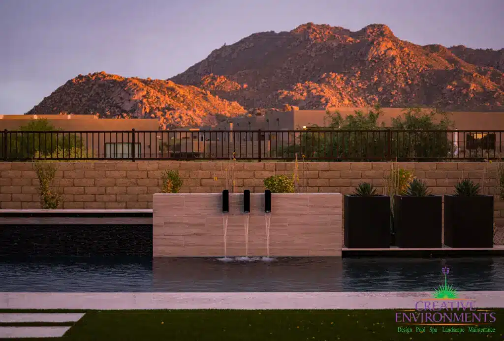 Custom backyard design with metal planters, metal scupper water feature and raised black spa.